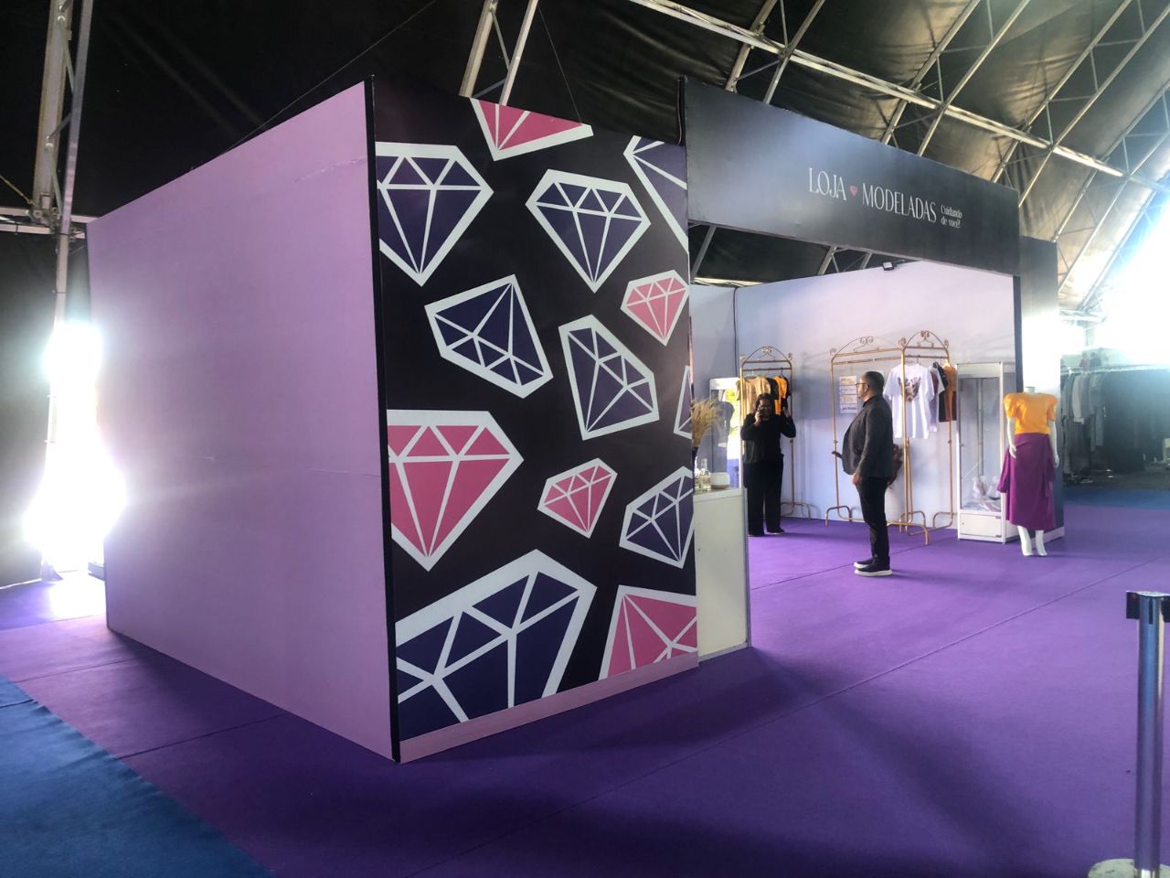 Painel decorativo em lona com estampa editorial de diamantes para stand de loja produzido pela Giga Projetos.