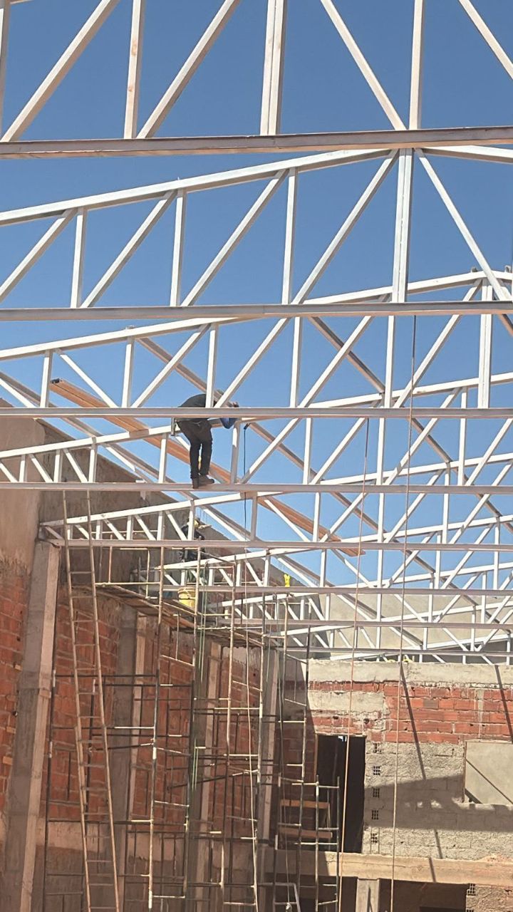 Etapa de execução de montagem de cobertura metálica para galpão pela equipe da Giga Projetos.