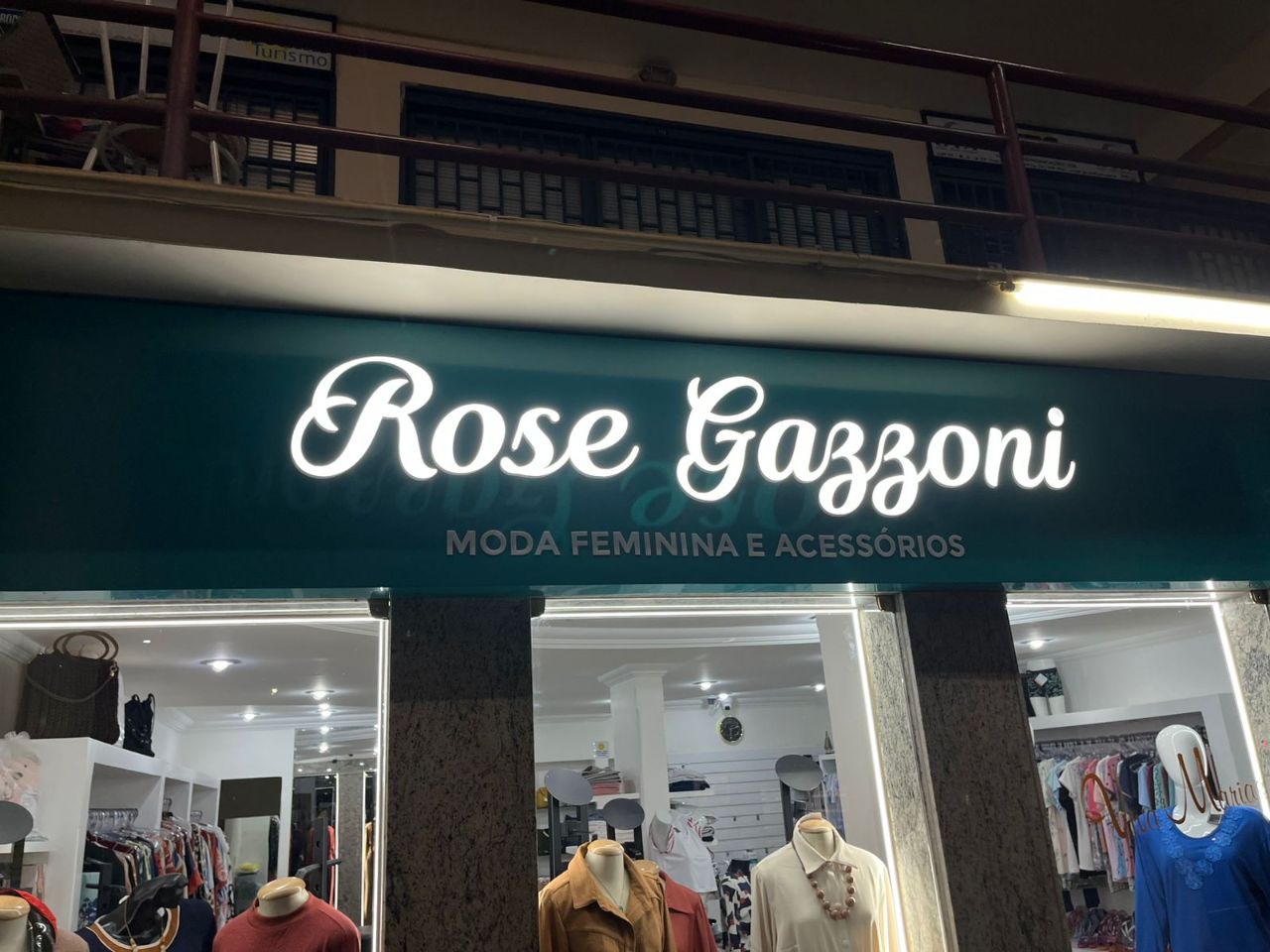 Fachada de loja Rose Gazzoni com letras caixa brancas iluminadas sobre fundo verde produzida pela Giga Projetos.