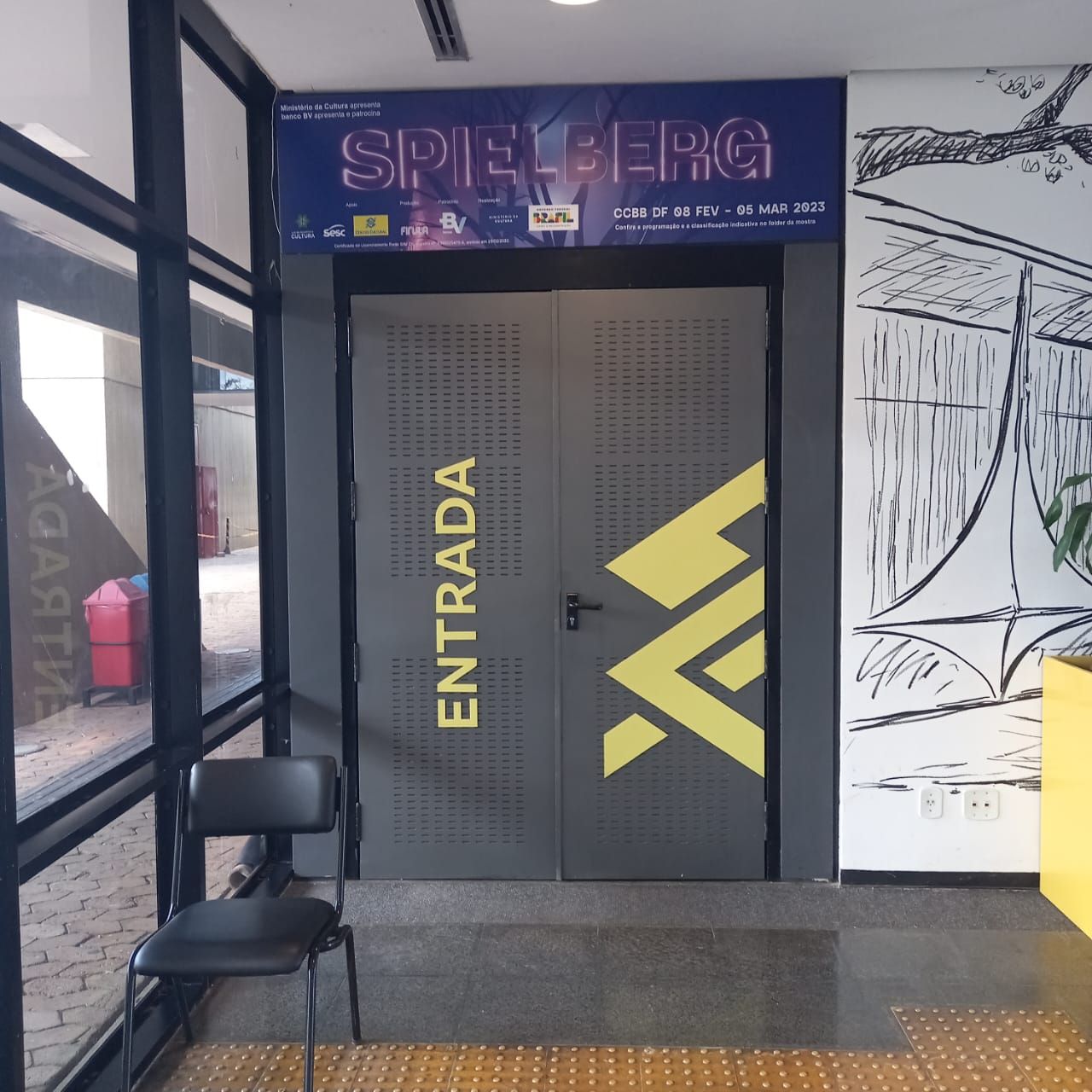 Envelopamento de porta de elevador para exposição Spielberg com design personalizado produzido pela Giga Projetos.